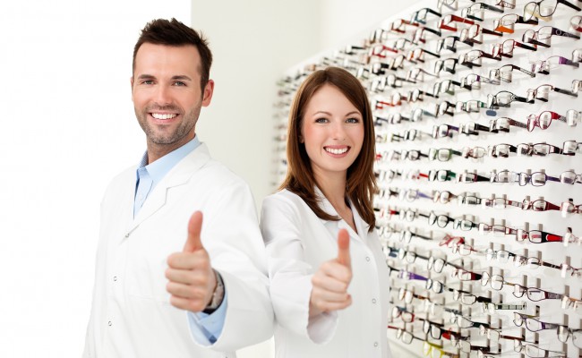 Two happy optician, optometrist showing thumbs up