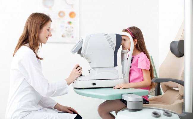 Optometrist examines the sight of young girl