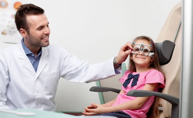 Optometrist examines the sight of young girl